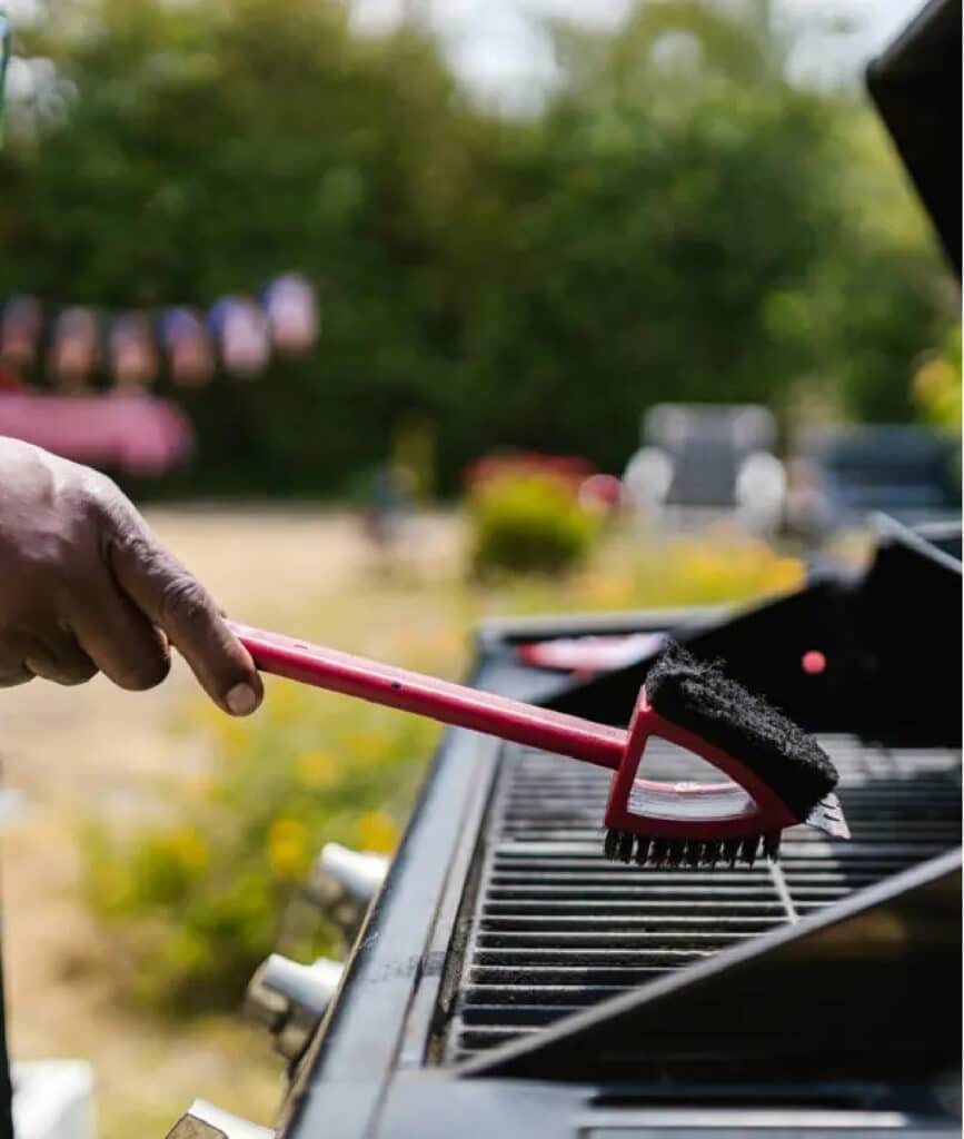 Technician cleaning a built-in stainless BBQ grill in Irvine
