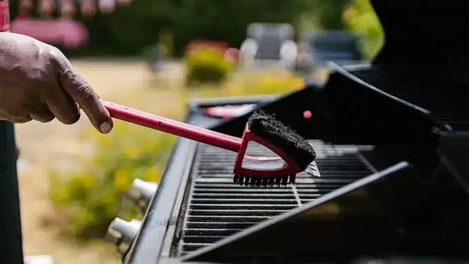 Certified technician performing a gas leak and safety inspection on an outdoor grill