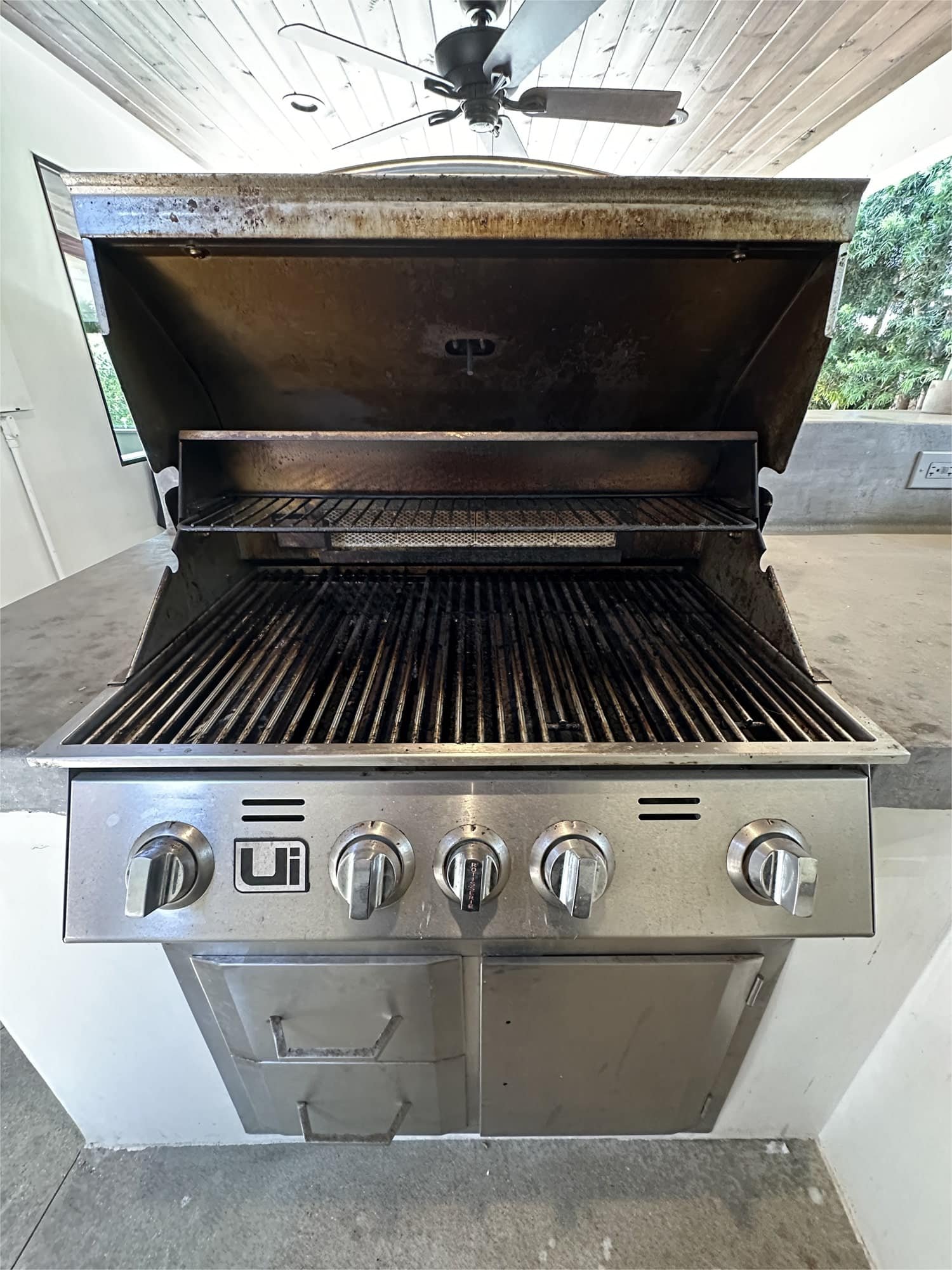 Dirty BBQ grill with heavy grease and carbon build‑up before professional cleaning