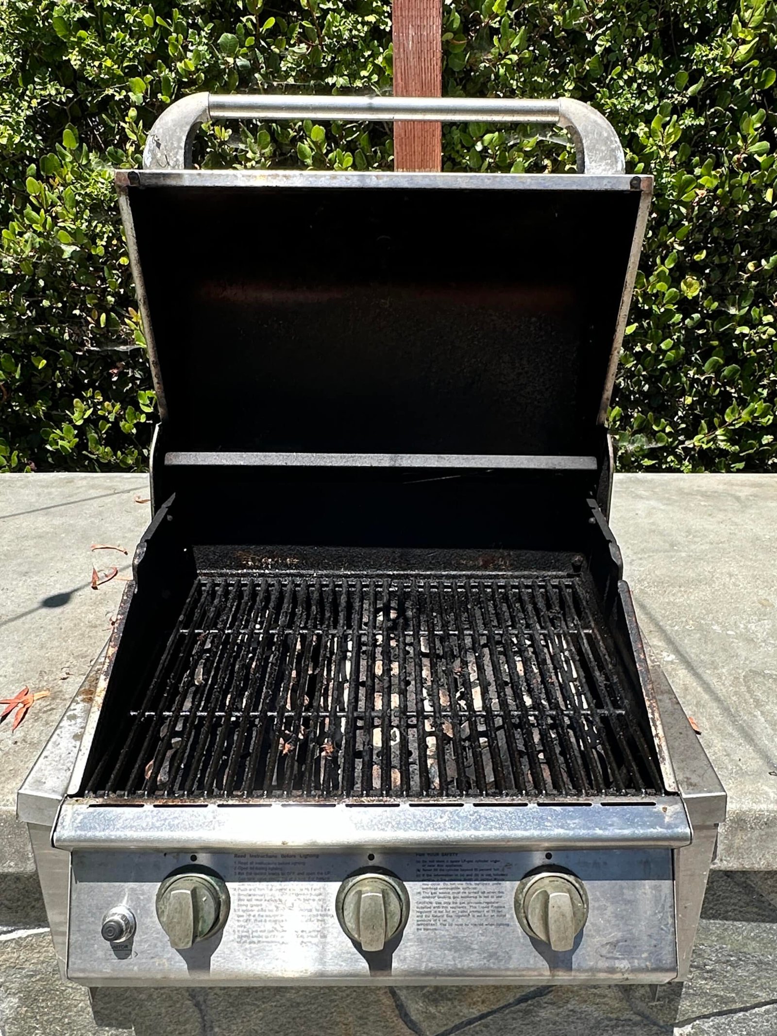 Outdoor grill burners clogged with debris prior to servicing